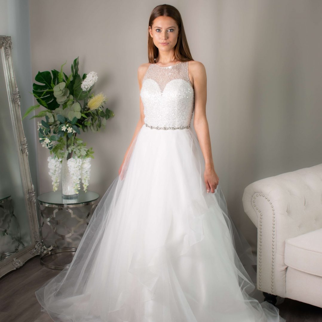 Ruth's sparkly wedding gown with a high beaded neckline and glittery tiered skirt from Divine Bridal