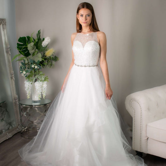 Ruth's sparkly wedding gown with a high beaded neckline and glittery tiered skirt from Divine Bridal
